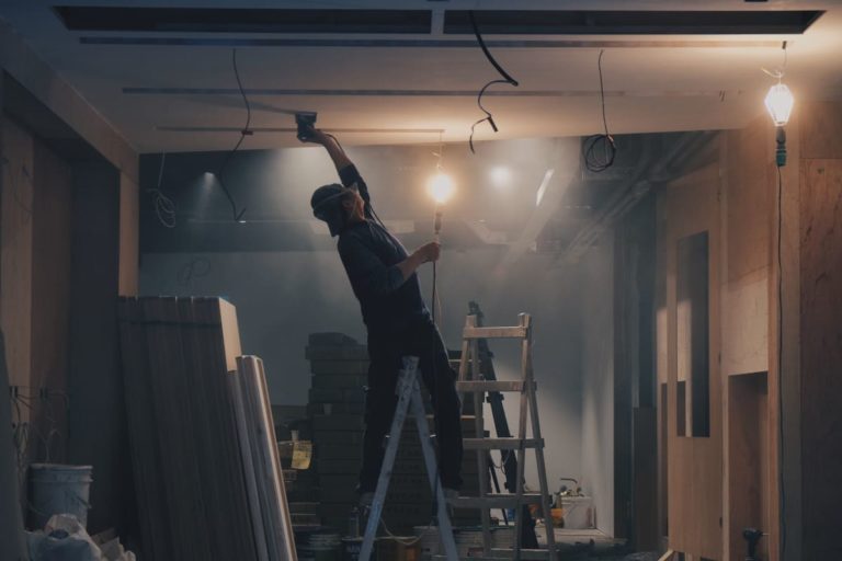 Homme travaillant dans son sous-sol pour isoler sa demeure et éviter la déperdition de chaleur