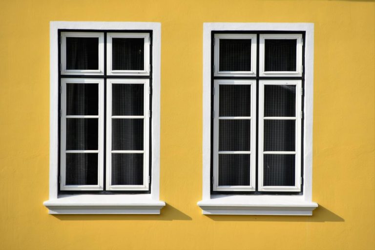 deux fenêtres sur mur jaune