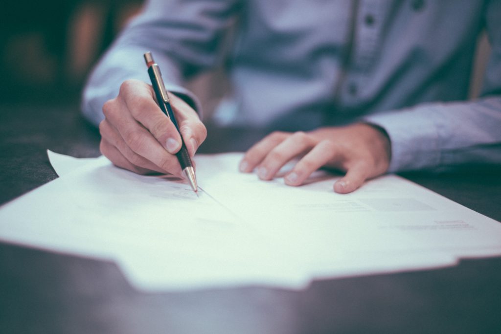 homme qui signe un contrat