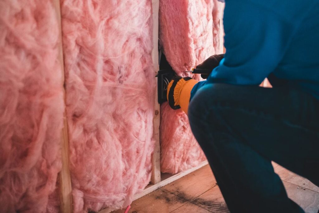 ouvrier isolant les murs d'une maison avec de la laine de verre