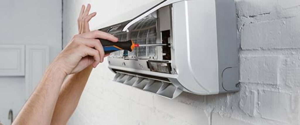 ouvrier avec tournevis pour réparer climatisation dans maison