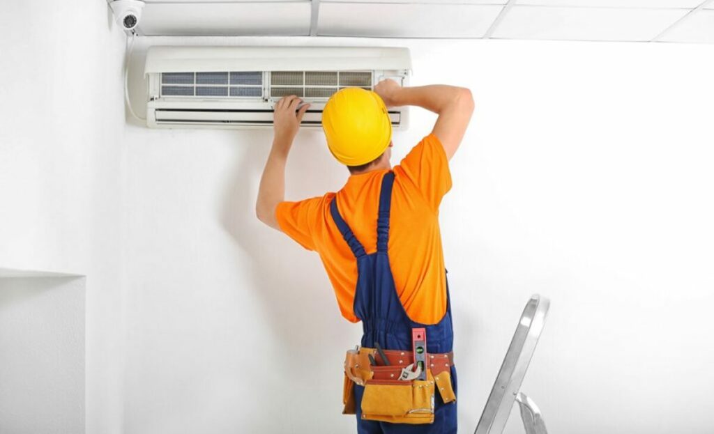 ouvrier réparant une climatisation dans maison