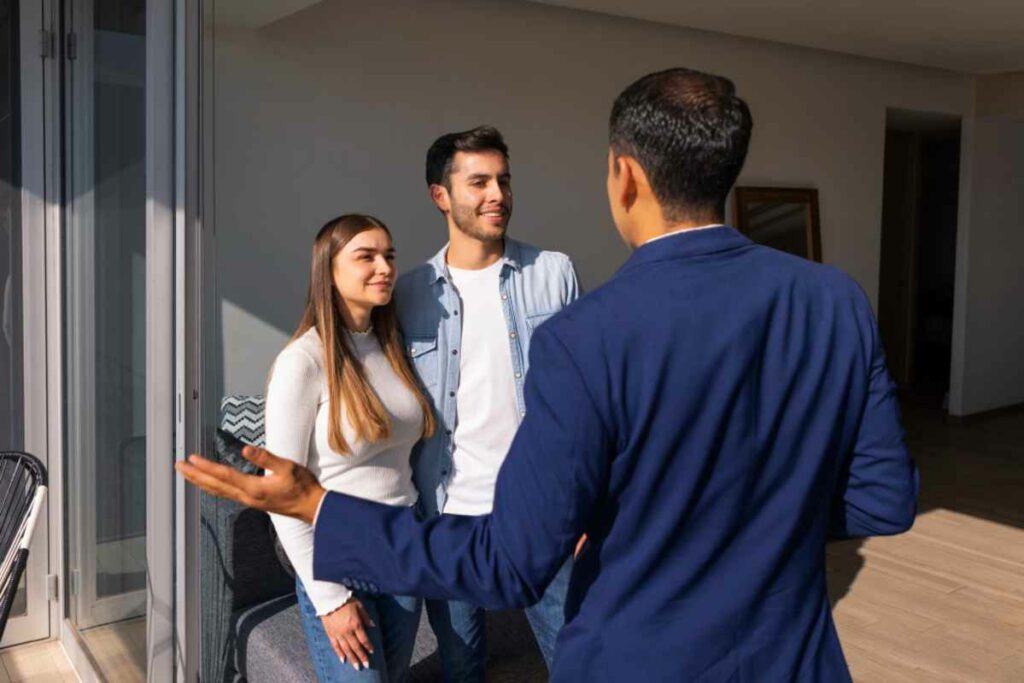 Marchand de bien dans un appartement avec un couple.